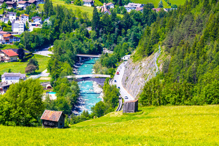 Mountain and alpine hill landscape mountains and peaks panorama view to Nesselgarten village town forest huts houses streets turquoise river Inn and green fields in Austria.の写真素材