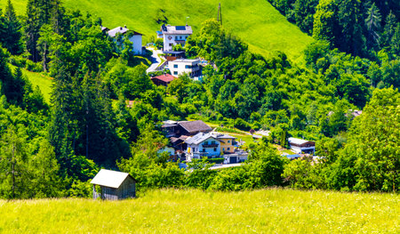 Mountain and alpine hill landscape mountains and peaks panorama view to Nesselgarten village town forest huts houses streets turquoise river Inn and green fields in Austria.の写真素材