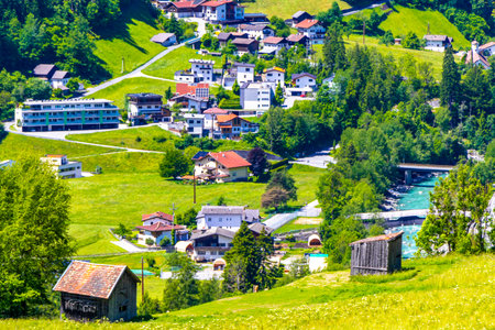 Mountain and alpine hill landscape mountains and peaks panorama view to Nesselgarten village town forest huts houses streets turquoise river Inn and green fields in Austria.の写真素材