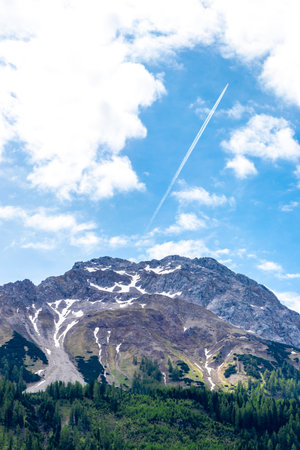Panoramic view of Marienberg mountain at Zugspitze alpine landscape with green forest rocks hills mountains and contrails in the Alps Biberwier Reutte Tyrol Austria.の写真素材