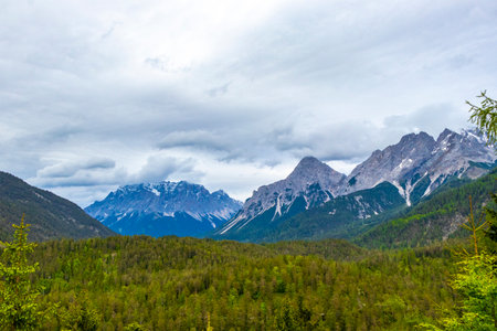 Panorama view of Germanys largest mountain Zugspitze alpine landscape with forest rocks hills snow peak clouds and mountains in the Alps Biberwier Reutte Tyrol Austria.の写真素材