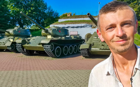 Man handsome tourist takes selfie at military soviet army battle war tank tanks monument monuments at the Brest Fortress in Leninskiy Rayon Brest Brest District Brest Region Belarus.の写真素材
