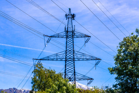 Power pole electricity pylon at mountain and alpine hill landscape mountains rocks and peaks...