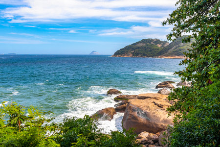 Urca Red Beach Tropical Paradise with Blue Turquoise Water Waves Palm Trees Rocks Hills Cliffs Seascape and White Beach Sand in Rio de Janeiro State of Rio de Janeiro Brazil.の写真素材
