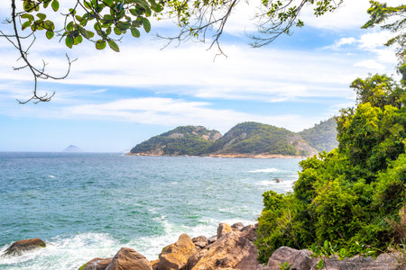 Urca Red Beach Tropical Paradise with Blue Turquoise Water Waves Palm Trees Rocks Hills Cliffs Seascape and White Beach Sand in Rio de Janeiro State of Rio de Janeiro Brazil.の写真素材