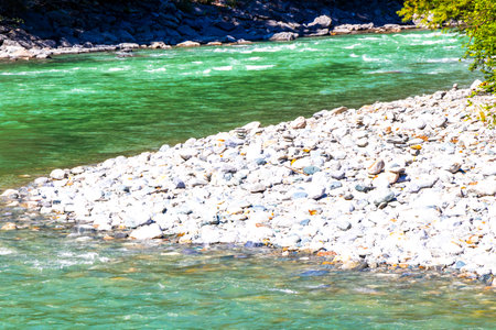 Turquoise blue and green river steam and waterfall Inn with stones rocks grass trees nature between mountains in the Alps Zams Landeck Tyrol Austria.の写真素材