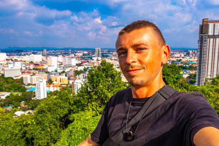 Handsome Man Tourist and Traveler with the Pattaya City Bay Beach Nature Jungle Pier and Boats Panorama View in Pattaya Bang Lamung Chon Buri Thailand.の写真素材