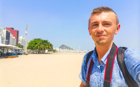 Male tourist takes selfie on Copacabana Beach Tropical Paradise with Blue Turquoise Water Palm Trees...