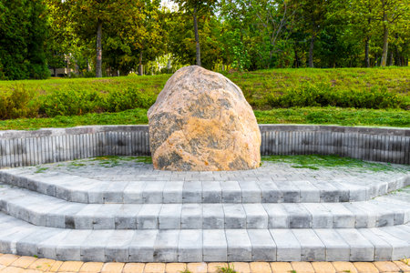 Minsk District Minsk Region Belarus September 10, 2020 Park with walking path field in green nature forest trees and big rock monument statue sculpture in Minsk Belarus.の写真素材