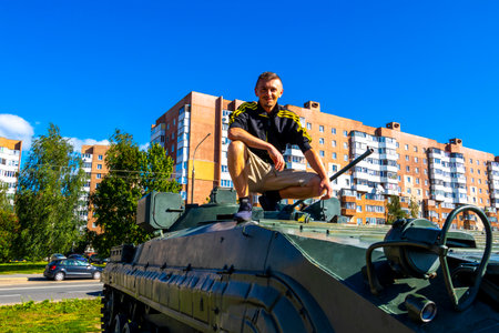 Handsome man tourist takes selfie photo with Russian war tank monument exhibition outside in Minsk...