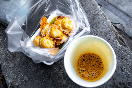 Cup of coffee and dessert Khanom Krok Thai coconut milk pancake street food in Don Mueang Bangkok Central Thailand in Southeastasia Asia.の写真素材
