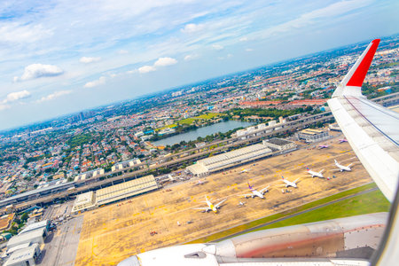 Flight over city town airport with panoramic panoramic view from the airplane cityscape skyline clouds and blue sky horizon in Don Mueang Bangkok Central Thailand in Southeastasia Asia.の写真素材
