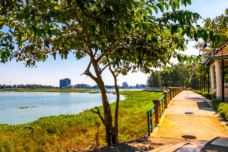 Kaen Nakhon lake with green tropical nature walking path and blue sky in the Bueng Kaen Nakhon...