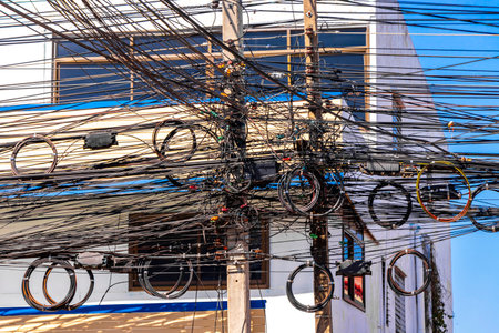 Khon Kaen Province Isan Thailand November 01, 2018 Extreme cable clutter on a power pole with blue...
