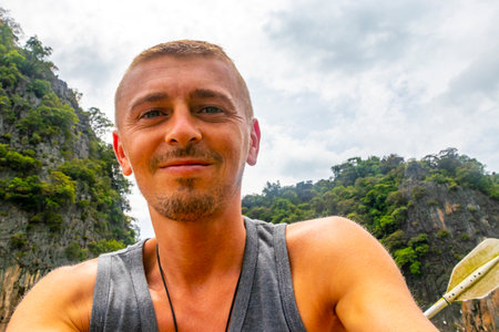 Man tourist with canoe in cave turquoise water and with limestone rocks on Koh Ko Hong Island in Krasom Amphoe Takua Thung District Phang Nga Province Southern Thailand.の写真素材