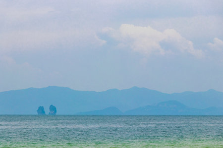 Seascape with mountains boats rocks and blue sky at the tropical beach on Koh Ko Na Khae Naka Island in Amphoe Takua Thung District Phang Nga Province Southern Thailand in Southeast Asia.の写真素材