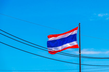 Thai flag in red white blue colors blowing in the wind with blue sky in Sakhu Thalang District on...