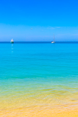 Tropical Mai Khao Beach and Naiyang Beach with jungle forest nature turquoise blue water waves and blue sky in Sirinat National Park Sakhu Thalang on Phuket island Province Southern Thailand.の写真素材