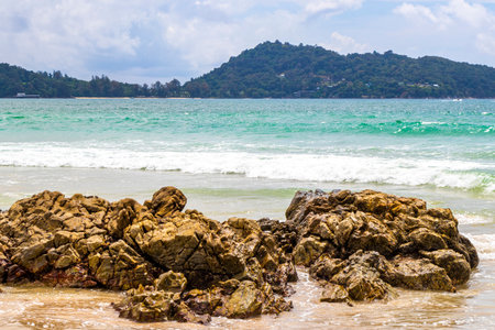Patong Beach bay sea coast panorama view with turquoise blue clear water waves white sand and green mountains and palm trees in Patong Beach Kathu District Phuket Island Province Southern Thailand.の写真素材