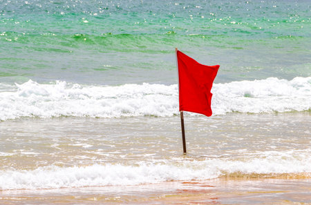 Patong Beach bay with red flag warning sign sea coast panorama view with turquoise blue clear water waves mountains palms in Patong Phuket Island Thailand.の写真素材