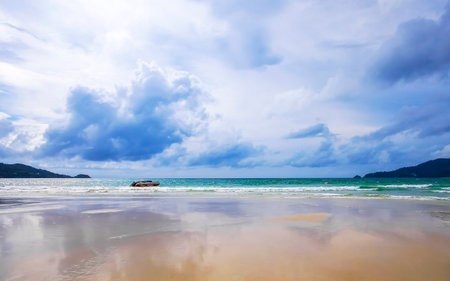 Patong Beach bay sea coast panorama view with turquoise blue clear water waves white sand and green mountains and palm trees in Patong Beach Kathu District Phuket Island Province Southern Thailand.の写真素材