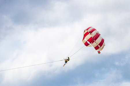 Kathu Phuket Thailand October 08, 2025 Patong Beach bay sea coast panorama view with people tourism and parasailing parachute sport activity water waves mountains and clouds in Patong Phuket Thailand.の写真素材