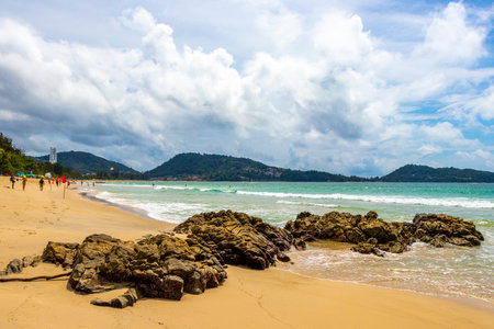 Patong Beach bay sea coast panorama view with turquoise blue clear water waves white sand and green mountains and palm trees in Patong Beach Kathu District Phuket Island Province Southern Thailand.の写真素材