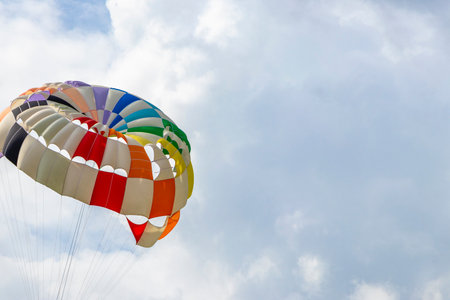 Kathu Phuket Thailand October 17, 2025 Patong Beach bay sea coast panorama view with people tourism and parasailing parachute sport activity water waves mountains and clouds.の写真素材
