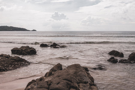 Amazing rocky beach tropical landscape panorama view with turquoise blue water waves and rocks.の写真素材
