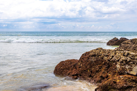 Amazing rocky beach tropical landscape panorama view with turquoise blue water waves and rocks in Patong Beach Kathu District Phuket Island Province Southern Thailand in Southeast Asia.の写真素材
