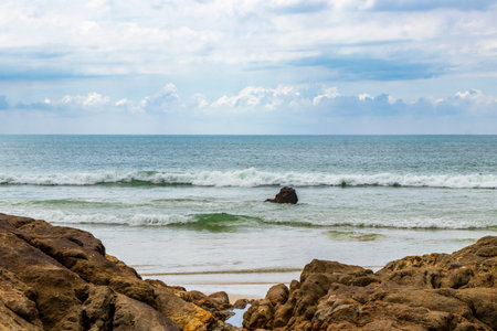 Amazing rocky beach tropical landscape panorama view with turquoise blue water waves and rocks.