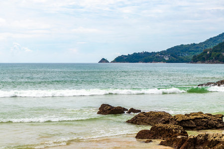 Amazing rocky beach tropical landscape panorama view with turquoise blue water waves and rocks.の写真素材