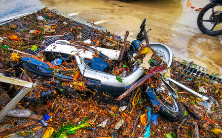 Kathu Phuket Island Thailand October 23, 2025 Extreme rainfall heavy monsoon rain and scooter with garbage trash on flooded city streets in Patong Beach Phuket Thailand.の写真素材