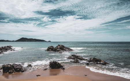 Amazing rocky tropical landscape panorama view with blue sky turquoise water waves and rocks in Patong Beach Kathu District Phuket Island Province Southern Thailand in Southeast Asia.の写真素材