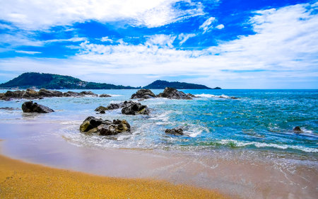 Amazing rocky Kalim Beach tropical landscape panorama view with blue sky turquoise water waves and rocks in Patong Beach Kathu District Phuket Island Province Southern Thailand in Southeast Asia.の写真素材