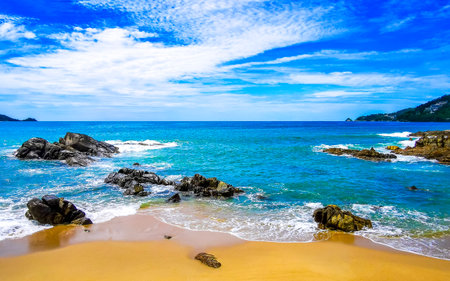 Amazing rocky Kalim Beach tropical landscape panorama view with blue sky turquoise water waves and rocks in Patong Beach Kathu District Phuket Island Province Southern Thailand in Southeast Asia.の写真素材