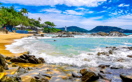 Amazing rocky Kalim Beach tropical landscape panorama view with blue sky turquoise water waves palm trees and rocks in Patong Beach Kathu Phuket Island Province Southern Thailand in Southeast Asia.の写真素材