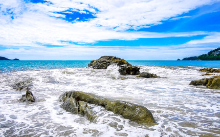 Amazing rocky Kalim Beach tropical landscape panorama view with blue sky turquoise water waves and rocks in Patong Beach Kathu District Phuket Island Province Southern Thailand in Southeast Asia.の写真素材