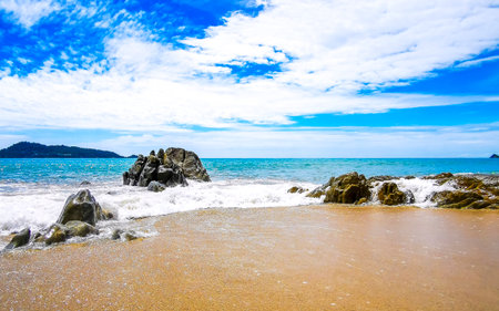 Amazing rocky Kalim Beach tropical landscape panorama view with blue sky turquoise water waves and rocks in Patong Beach Kathu District Phuket Island Province Southern Thailand in Southeast Asia.の写真素材