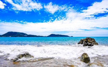 Amazing rocky Kalim Beach tropical landscape panorama view with blue sky turquoise water waves and rocks in Patong Beach Kathu District Phuket Island Province Southern Thailand in Southeast Asia.の写真素材