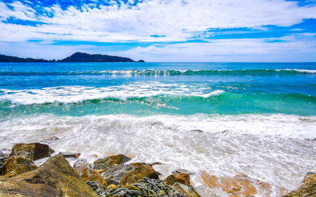 Amazing rocky Kalim Beach tropical landscape panorama view with blue sky turquoise water waves and rocks in Patong Beach Kathu District Phuket Island Province Southern Thailand in Southeast Asia.の写真素材