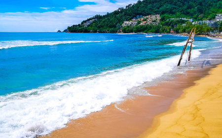 Kalim Beach bay sea coast panorama view with turquoise blue clear water waves white sand and green mountains and palm trees in Patong Beach Kathu Phuket Island Province Southern Thailand.の写真素材