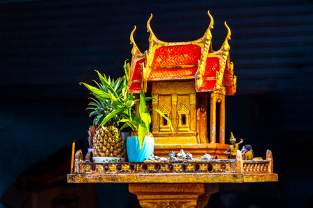 Holy beautiful yellow red orange brown golden Thai spirit house in Patong Beach Phuket Island Province Southern Thailand.の写真素材