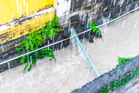 Small tropical green city river canal and drainage in jungle nature full during a heavy monsoon rainfall in Southeast Asia.の写真素材
