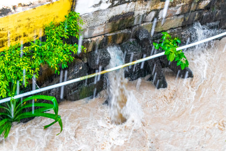 Small tropical green city river canal and drainage in jungle nature full during a heavy monsoon rainfall in Patong Beach Kathu District Phuket Island Province Southern Thailand in Southeast Asia.の写真素材