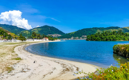 Panorama of tropical Anil Beach with coastal shore seascape turquoise green clear water pier port harbor with boats blue sky and palm trees.の写真素材