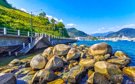Panorama of tropical island nature coast beach with turquoise green and clear water rock rocks boulders boulder and blue sky in Angra dos Reis State of Rio de Janeiro Brazil.の写真素材