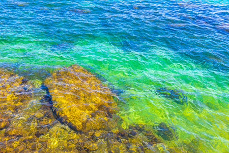 Rocks boulder boulders in turquoise green blue water at beach shore and coast in Angra dos Reis State of Rio de Janeiro Brazil.の写真素材