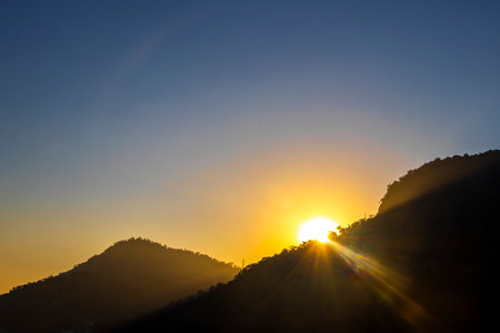 Beautiful golden colorful sunrise sunset behind the tropical mountain mountains hill hills.の写真素材