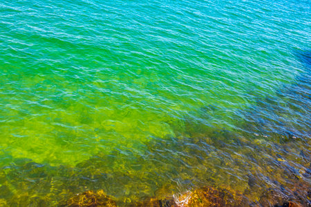Rock boulder boulders in turquoise green blue water at beach shore and coast in Angra dos Reis State of Rio de Janeiro Brazil.の写真素材